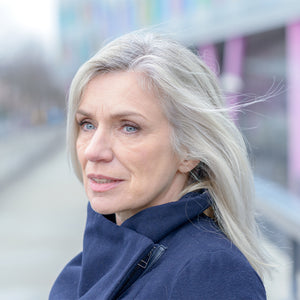 seitliches Portrait einer Frau gehobenen Alters mit grauem Haar